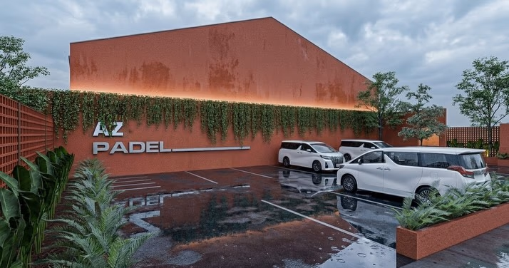 The signage wall at dusk, trailing planting washed by cove light over rendered terracotta