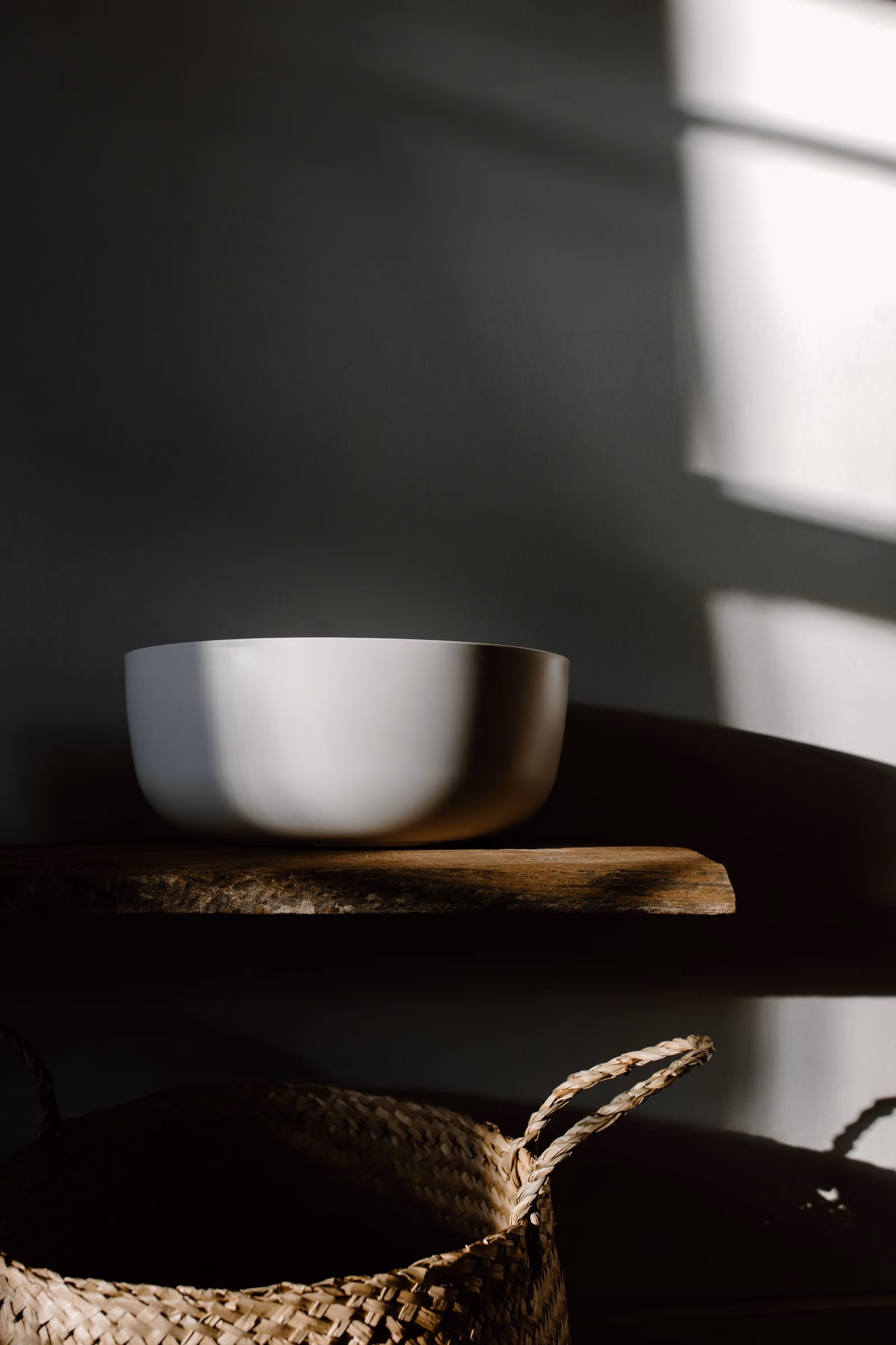 A single ceramic bowl on a dark timber table, everything else left out of frame