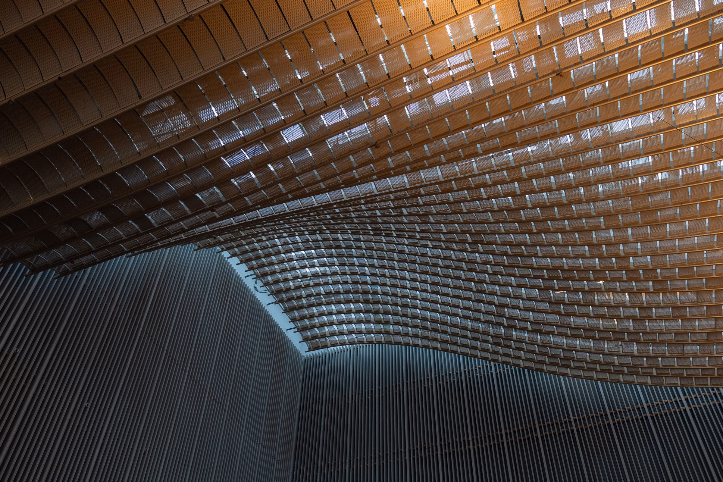 A vaulted ceiling of stacked brick curving overhead, every course left visible